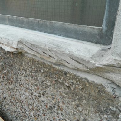 Betonfensterbank mit abgeplatzten Stellen