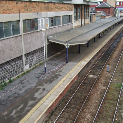 Betonwand mit starken Schäden durch Abplatzungen an einem Bahnhof