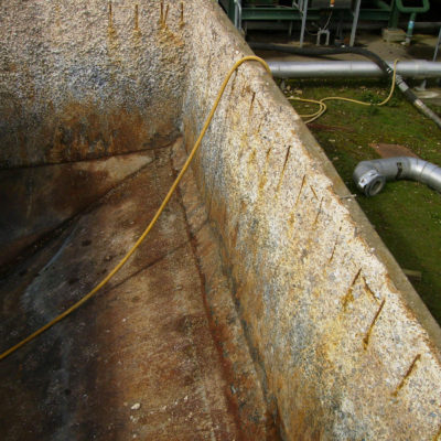 Durch chemische Korrosion in einem Abwassertank stark angegriffene Armierung und beschädigter Beton